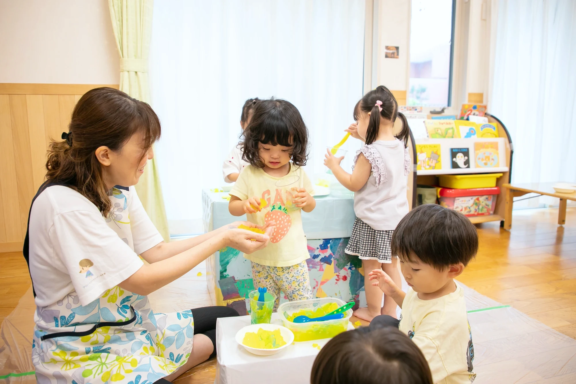 保育士と一緒に制作を楽しむ子ども
