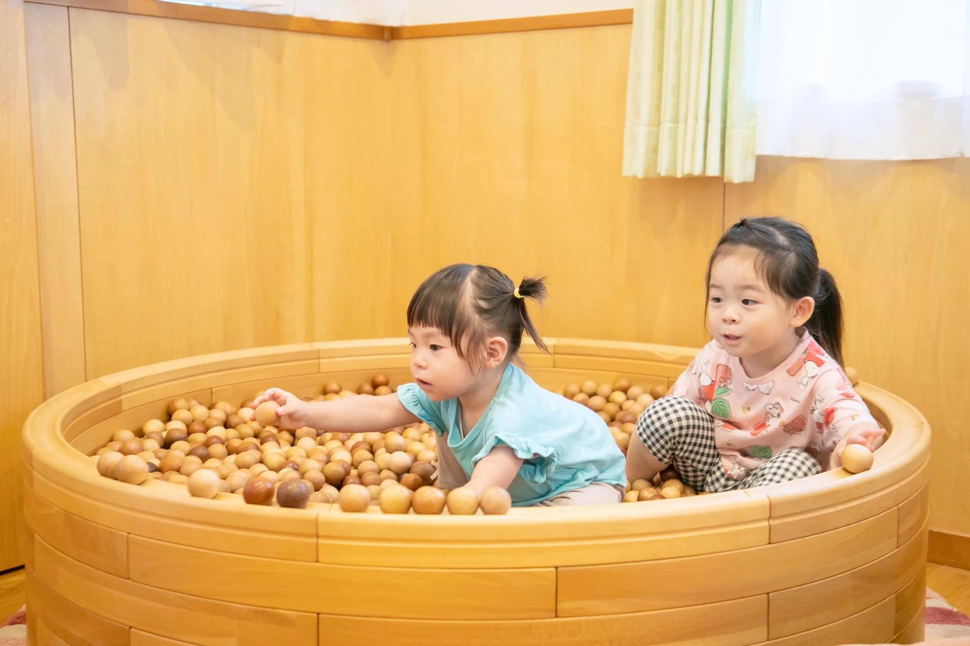 木のボールプールで遊ぶ子どもたち